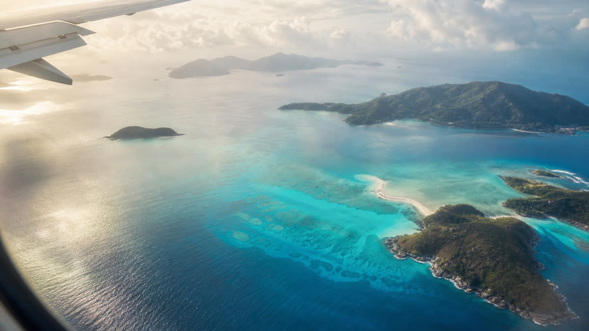 Vue aérienne d’un avion approchant les Seychelles au-dessus d’un lagon turquoise